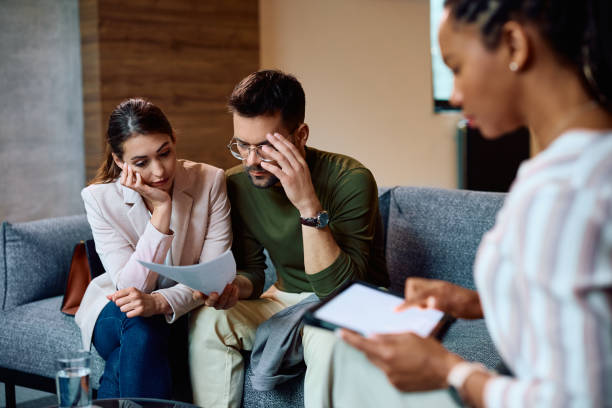 istock Worried couple going through financial reports during a meeting with insurance agent. 1490901220