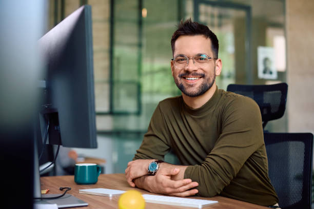 istock Happy male entrepreneur at  his office desk looking at camera. 1490901345