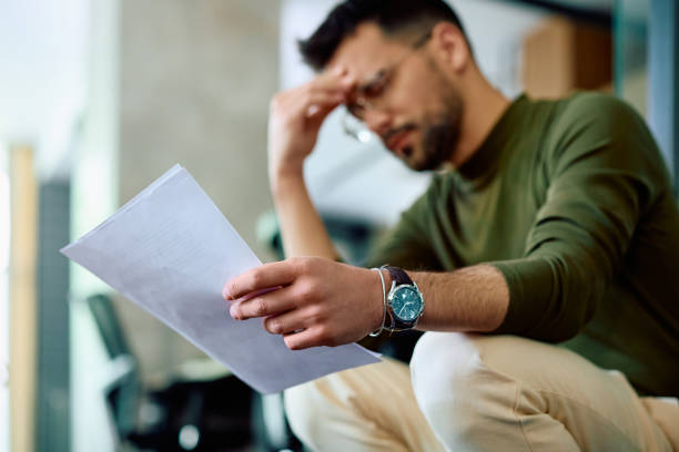 istock Close up of worried businessman analyzing documents in the office. 1490901378