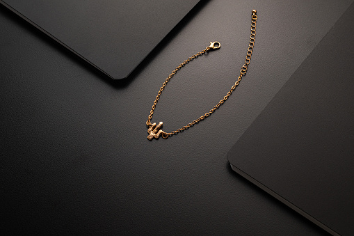 A beautiful gold necklace with a heart-shaped pendant. The necklace is made of a delicate chain and the pendant is set with small diamonds. The necklace is perfect for a special occasion or for everyday wear.