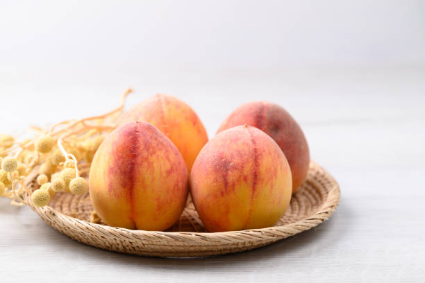 Ripe Peaches fruit in basket on white table
