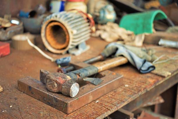 istock Old hammer with a wooden handle wrapped in electrical tape on a joiner's desk. Garage Tools 1490909397