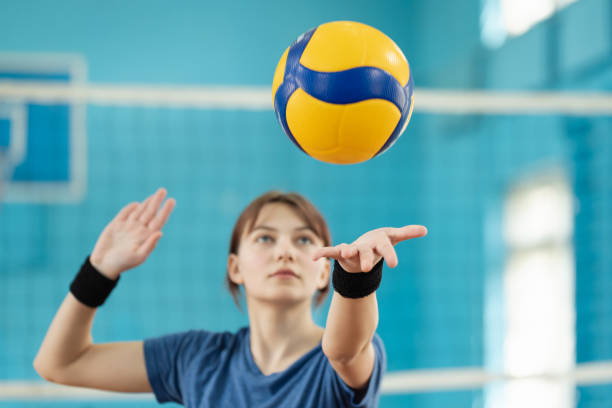 Photo in action of a young girl serving the ball stock photo