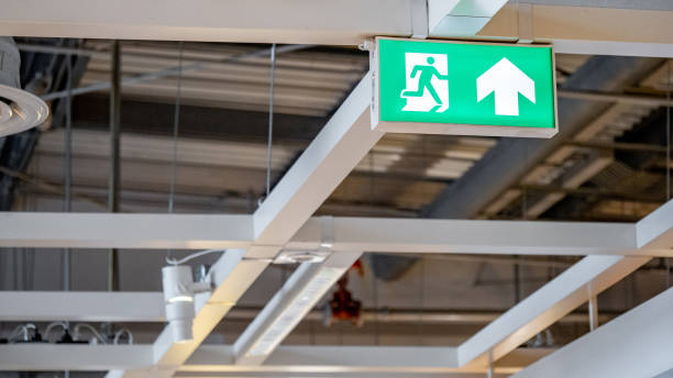 istock Green emergency fire exit sign showing the way to escape with an arrow symbol. 1490912099