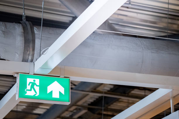 istock Green emergency fire exit sign showing the way to escape with an arrow symbol. 1490912109