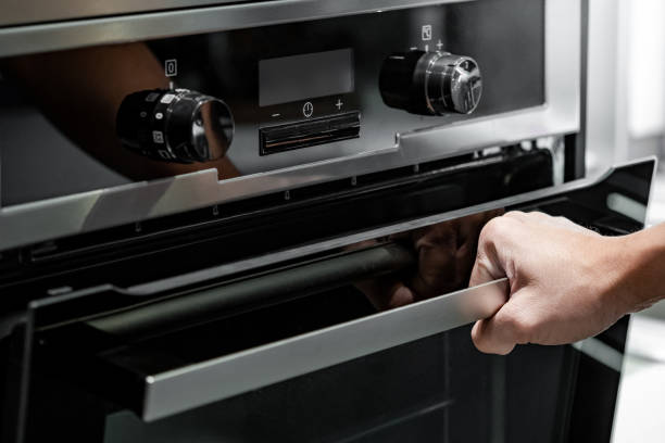 istock Male hand pulling oven door handle in modern kitchen. Cooking appliance for domestic kitchen. 1490912864