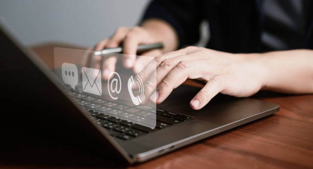 istock Businessman is shown using laptop and touching virtual screen contact icons such as email, address 1490913956