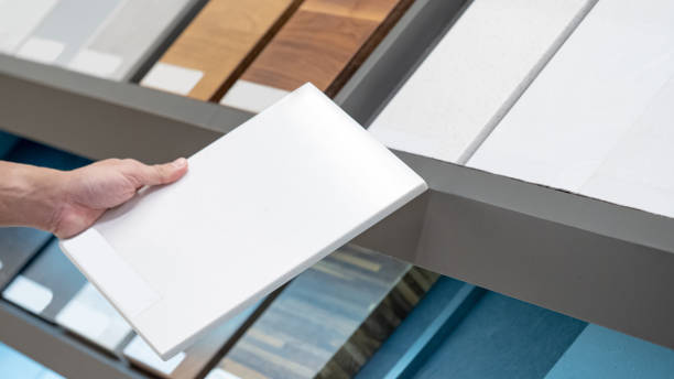 istock Home interior material design. Male hand choosing sample of white ceramic tile for floor and wall finishing 1490915073