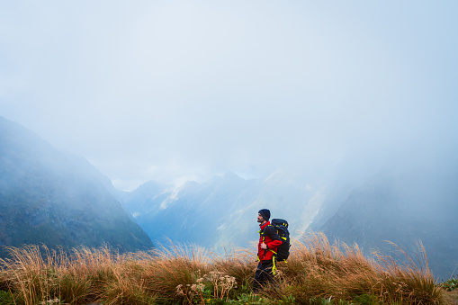 One solo man hiker hiking through Mackinnon Pass, Milford Track, South Island, New Zealand.