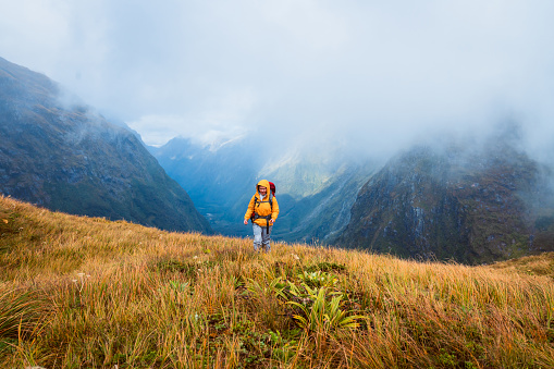 One solo woman hiker hiking through Mackinnon Pass, Milford Track, South Island, New Zealand.