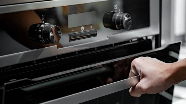 istock Male hand pulling oven door handle in modern kitchen. Cooking appliance for domestic kitchen. 1490918863