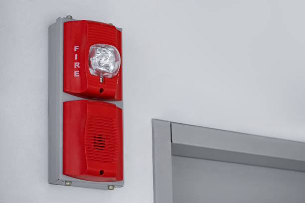 Fire alarm strobe/horn being installed on a wall