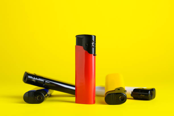 istock Stylish small pocket lighters on yellow background 1490921419
