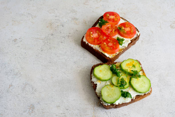 istock A sandwich with cucumber,  tomato and chopped parsley on a grey table, copy space 1490921743