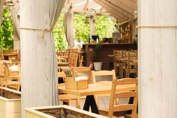 istock Empty restaurant terrace in the park with wooden tables and chairs 1490926134