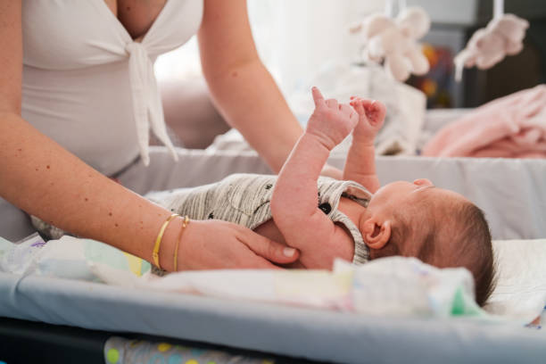 istock Mother changing 1 month old baby's clothes. 1490926409