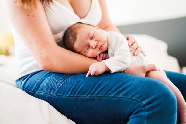 istock Mother putting her baby to sleep on her lap 1490927093