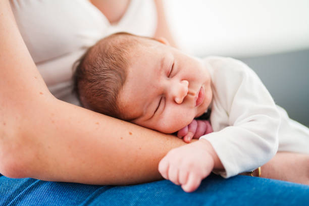 Mother putting her baby to sleep on her knee