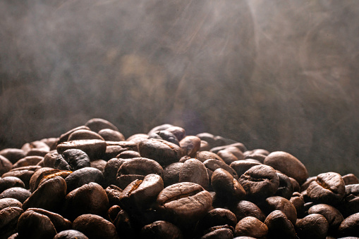 Coffee beans roasting with smoke,  selective focus, and soft focus.