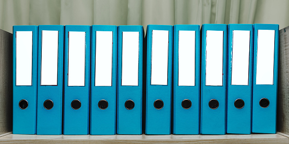 Mockup with white spine label of office document folders standing on wooden shelf in row