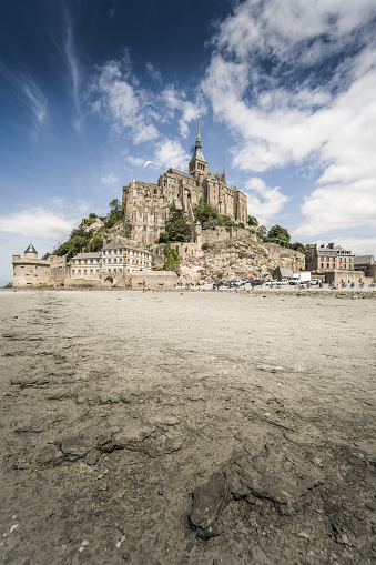 This stunning photo captures the iconic landscape of Mont Saint-Michel in France. Perched on its rocky islet, this natural masterpiece emerges majestically from the waters during the tides. The towers of the abbey and medieval buildings proudly stand, showcasing the rich history and remarkable architecture of this UNESCO World Heritage site.