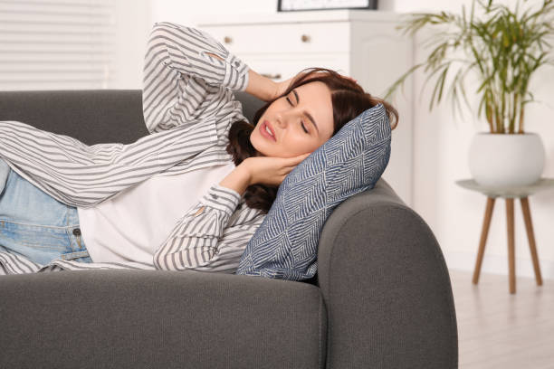 istock Young woman suffering from headache on sofa indoors. Hormonal disorders 1490933694