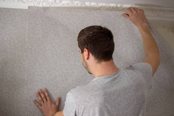 istock A man glues wallpaper, repairs the house. 1490934036