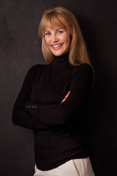 istock Beautiful smiling woman standing at isolated dark background 1490937440