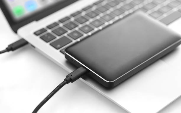 portable usb hard drive connected to laptop - data transfer, backup - memory card imagens e fotografias de stock