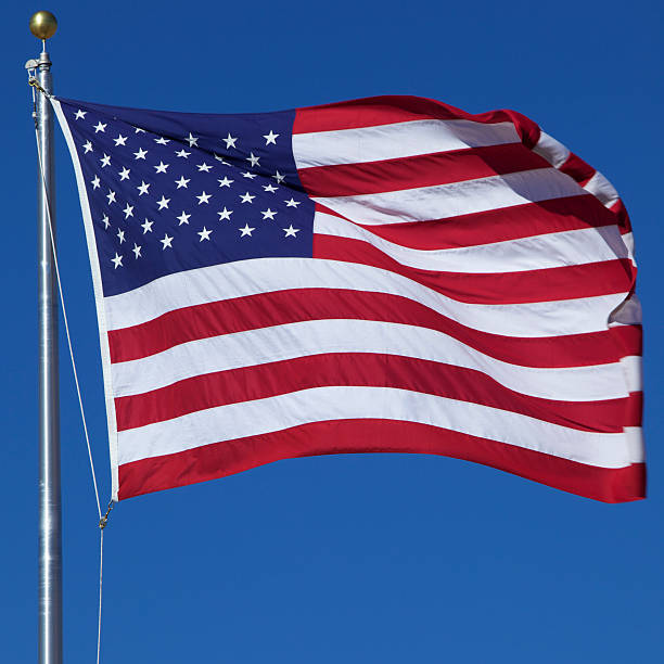 istock American flag waving in blue sky 149094082