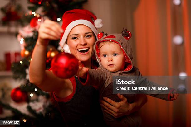 Happy Mother Showing Christmas Ball To Baby Stock Photo - Download Image Now - Baby - Human Age, Christmas, Mother