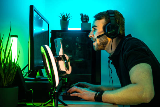 istock Man playing videogames at home using keyboard, monitor and headset. 1490942301
