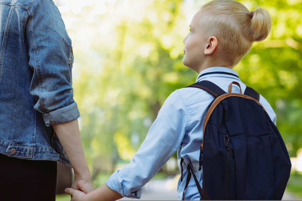 istock mother and son going to school holding hands 1490942996
