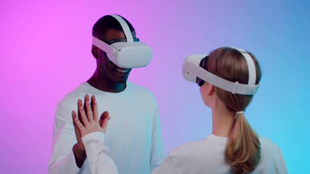istock Multiethnic couple play virtual reality simulation in goggles isolated over neon background. 1490944361