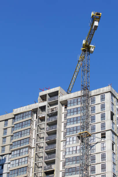 istock Construction site. Reinforced concrete frame of a multi-storey building and construction cranes. The final stage of construction. Against the background of the blue sky. 1490945870