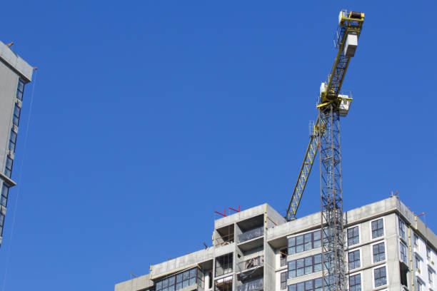 istock Construction site. Reinforced concrete frame of a multi-storey building and construction cranes. The final stage of construction. Against the background of the blue sky. 1490946101