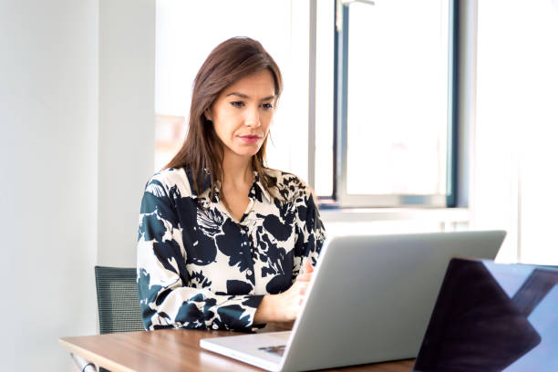 istock Mid aged businesswoman sitting in a modern office and using laptop for work 1490946178