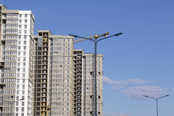 istock Construction site. Reinforced concrete frames of multi-storey buildings and construction cranes. Against the background of the blue sky. 1490946224