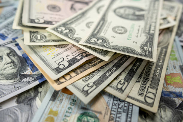 istock 1 2 5 10 100 Different dollar bills in a pile as background 1490947100