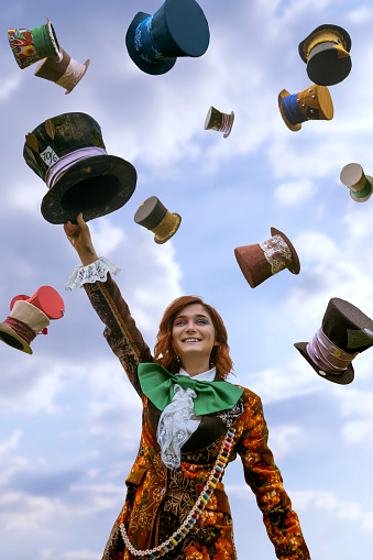 Beautiful woman as mad hatter with hats in nature