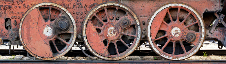 Rusty red wheels of very old obsolete steam locomotive