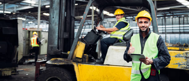 istock Engineer are working in the factory. Mechanical technicians are maintaining the engine. Worker with a forklift in a warehouse. 1490955170