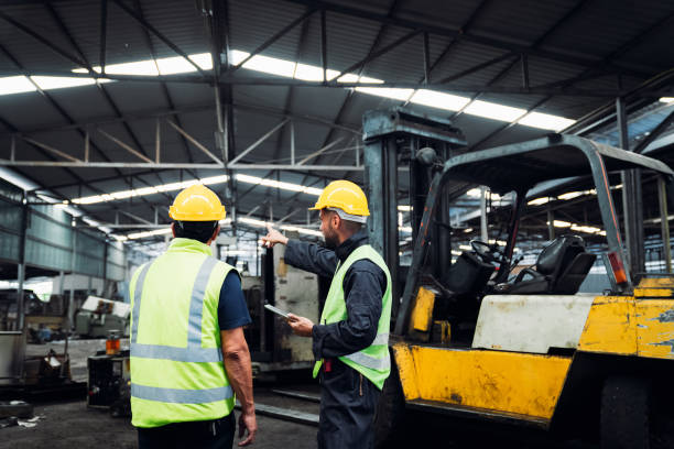 istock Engineer are working in the factory. Mechanical technicians are maintaining the engine. Worker with a forklift in a warehouse. 1490955641