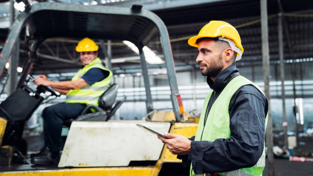 istock Engineer are working in the factory. Mechanical technicians are maintaining the engine. Worker with a forklift in a warehouse. 1490956450