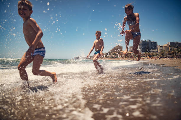 istock Kids having extreme fun running on the beach and splashing 1490956679