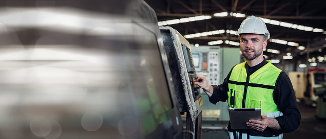 Portrait of engineer is working in the factory. Mechanical technicians are maintaining the engine.