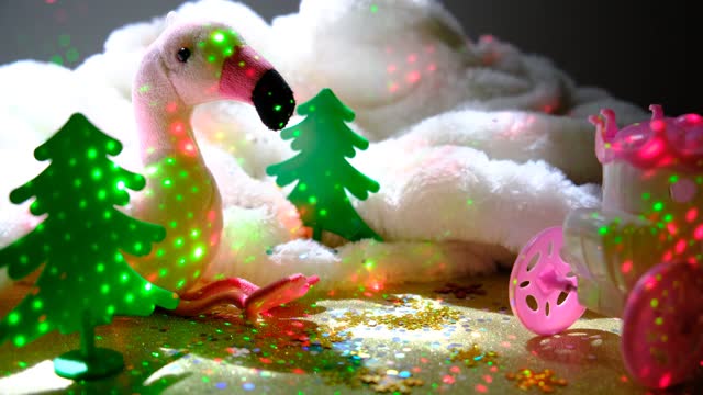 Winter Fairy Festive background. Christmas atmosphere with cute toys. Stuffed funny toy pink flamingo . Blinking lights