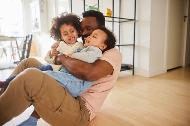 istock Loving dad sitting with his young sons on his lap at home 1490960402