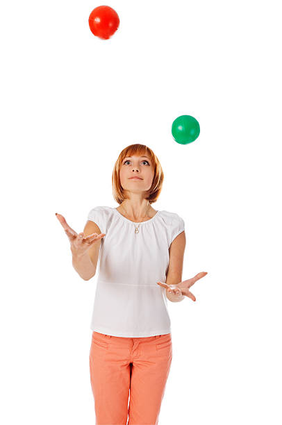 Beautiful red girl juggling balls on white stock photo