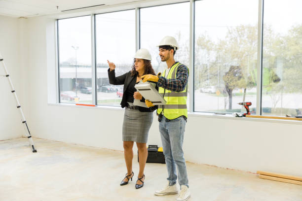 istock Female business owner asks the construction worker questions about the design plans 1490969985